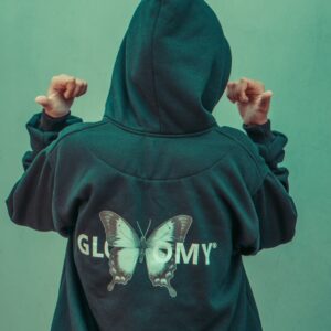a person wearing a green hoodie with a butterfly on it